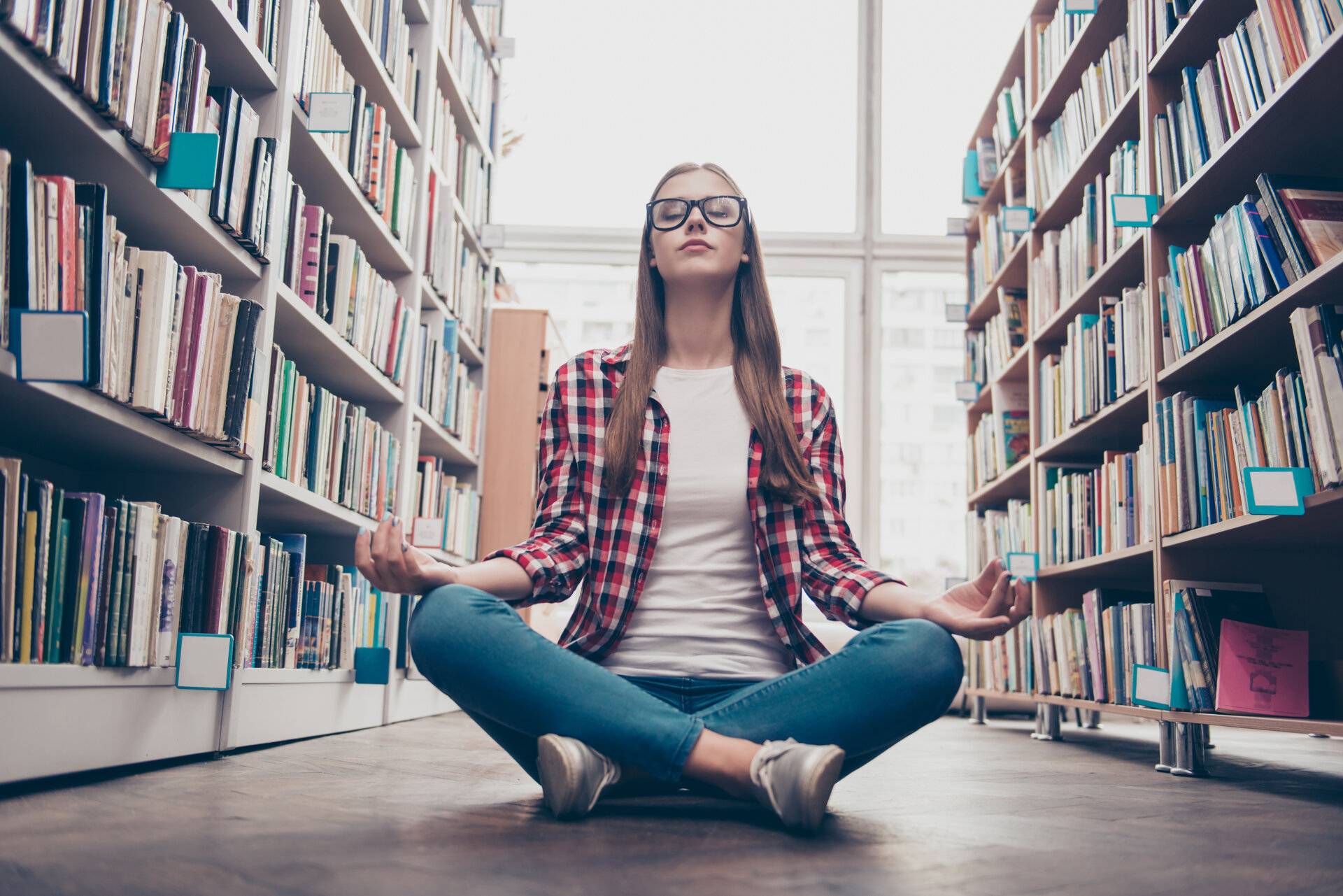 Frau macht Yoga in der Bibliothek